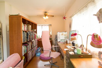 仕事スペースは、リビングを可動式の本棚で仕切った。椅子やソファーはパステルピンクで統一。