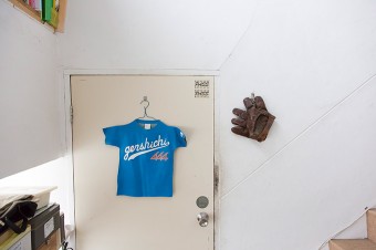 アトリエのドアにかかるブルーのTシャツは、革製の看板。