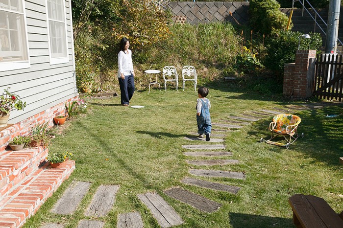 庭で遊ぶ修司くんと雅子さん。夫妻で芝を貼り、木を植えるなどガーデニングを楽しんでいる。