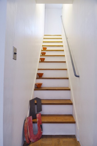 狭さを感じる階段も、白く塗ることで広がりを。キャンドルなどをディスプレイ。