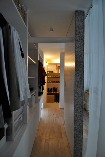 寝室を囲むように、クローゼットと吹き抜けが回廊式に配置されている。正面が玄関脇の靴の収納スペース。