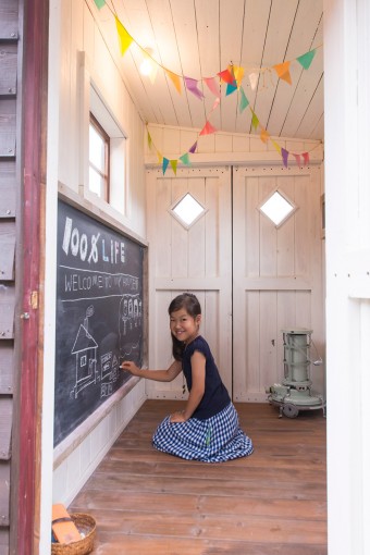 小屋の中は、現在は白く塗装し、子供たちが喜ぶ空間にディスプレイ。お絵描き用の黒板も備えられ、子供たちの秘密基地となっている。