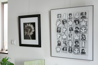 玄関にも写真や絵を飾って。右の作品は、丈幸さんがアメリカに留学していたときに描いたものだそう。