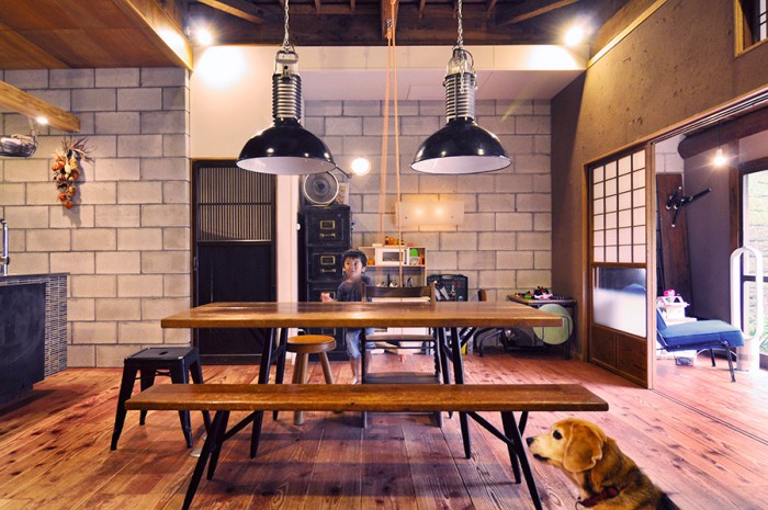 日本家屋にコンクリートブロックの壁が新鮮な組み合わせ。ダイニングテーブルには武骨なインダストリアルデザインのライトが２灯、70年代フランスPhilips社製。その下はイルマリ・バピオヴァーラのテーブルとベンチのセット。