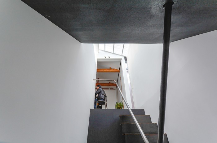 階段室から2階のリビングダイニングを見上げる。黒と白の仕上げのコントラストが際立つ空間。
