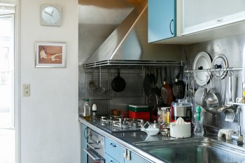 使い込まれたキッチンには、鍋などが使い勝手よく配置されている。時計下の写真は、マンションにいた頃から飼っていた先代猫のこばん。