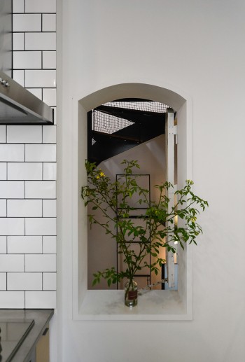 キッチンから階段室を見る。扉の形に合わせてくり抜かれた壁の上部がアールになっている。