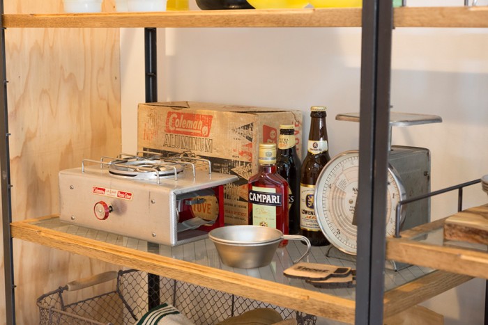 このヴィンテージのコールマンのバーナーの他にも、年代もののランタンなど、味のあるキャンプ道具が棚に並ぶ。