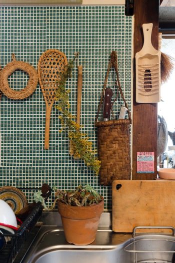 青磁色のタイルを貼った壁に、会津のマタタビを使った台所道具やカゴを。