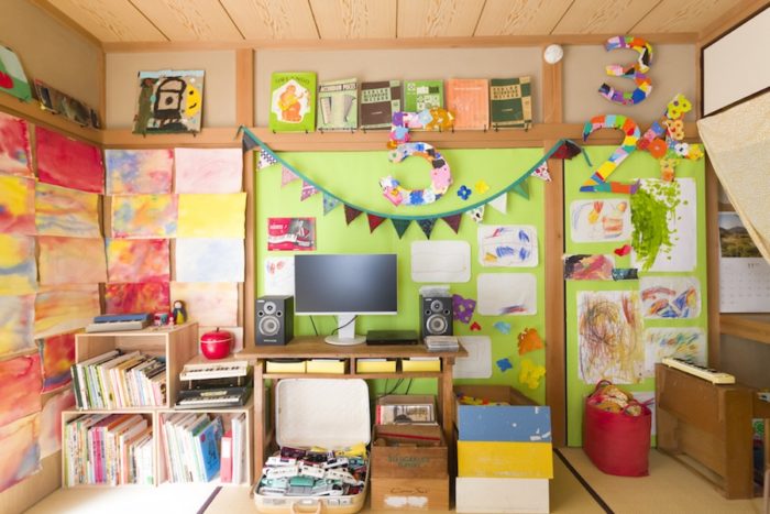 子供部屋でもありリビングでもある部屋は、黄緑色の壁をベースに子供の作品などを飾り、明るく楽しく。「壁紙を貼ると気分があがります」。
