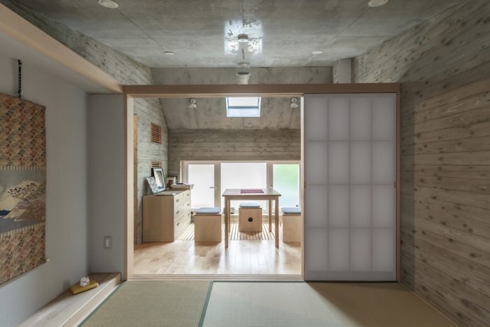 和室からスノコペースと呼ばれる空間を見る。杉板型枠を使って打設したコンクリートの壁面が和室としっくりと合う。