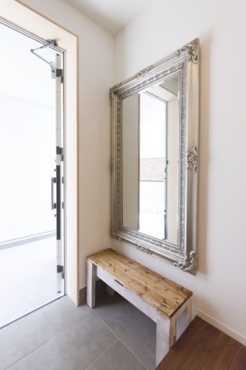 玄関のアンティークな鏡は奥さまの持ち込み。椅子はダイニングテープル等と同じパイン材の造作。