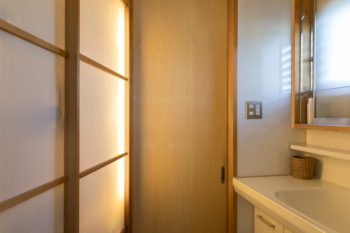 障子越しの間接照明が空間をやさしく照らす洗面室。障子の中は収納になっている。
