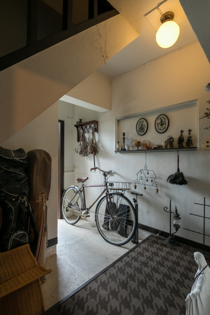 玄関は自転車を置ける広さがある。階段下の斜めの壁が空間に味わいを加えている。