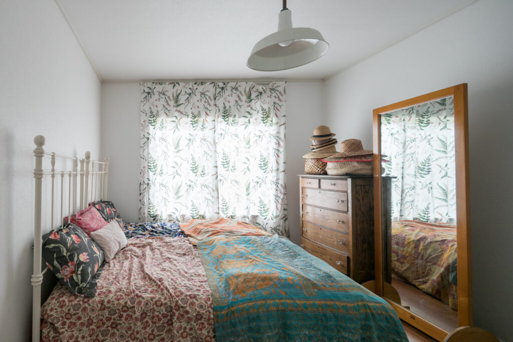 にぎやかな柄のファブリックや年代物の木の家具が、温かみを感じさせてくれる寝室。