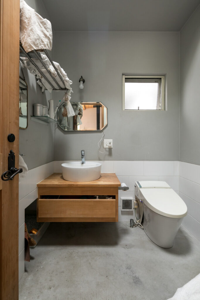 洗面台は宙に浮いたクローゼットの上に置かれたようなスタイル。八角形の鏡も素敵。