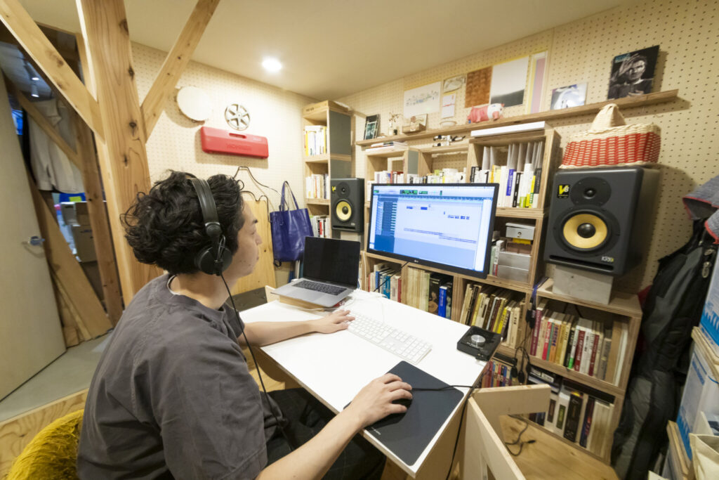 アトリエ倉庫の右奥が、亮さんの音楽スタジオ。防音設備も完備。PCを載せているのは組み立て・解体自在のペケ台（簡易作業台）。