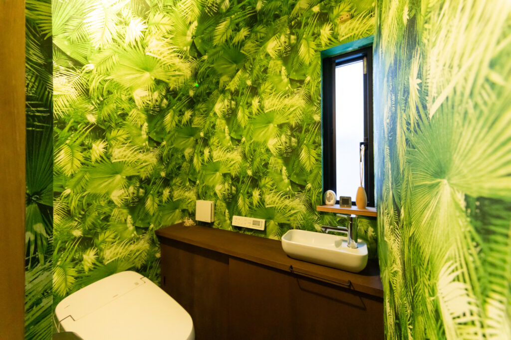 大胆な壁紙でジャングル化したトイレ！　階段下の空間を有効利用している。