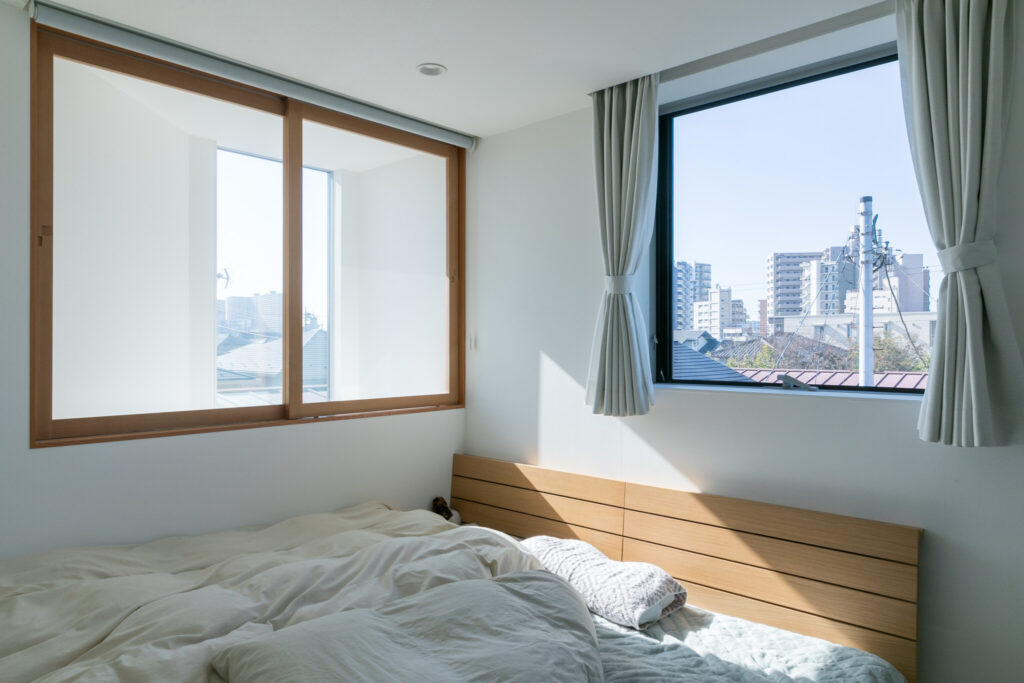 ３階寝室。かわいらしい木製サッシの窓から心地よい光が差し込む。